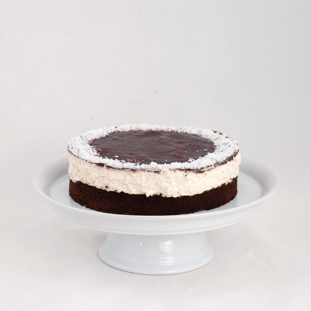 Vegane Kokos-Schoko-Torte  auf weißem Teller von der Seite